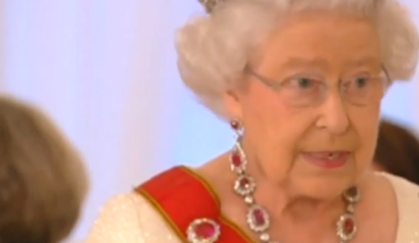 Queen Elizabeth II wearing a diamond tiara and a ruby and diamond necklace and brooch