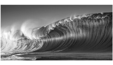 Photograph titled 'Exploding Swell' by Ted Grambeau of Australia, winner of the General (black and white) category in the 14th season of the HIPA (Hamdan bin Mohammed bin Rashid Al Maktoum International Photography Award) photography competition. Image description: On a Pacific reef, a massive swell surges, its waves crashing with unrelenting force. Spray erupts upward, curling in wild arcs before collapsing into the churning sea. The ocean's raw power is vividly displayed through this magnificent wave, a dream for surfers and a captivating subject for photographers.