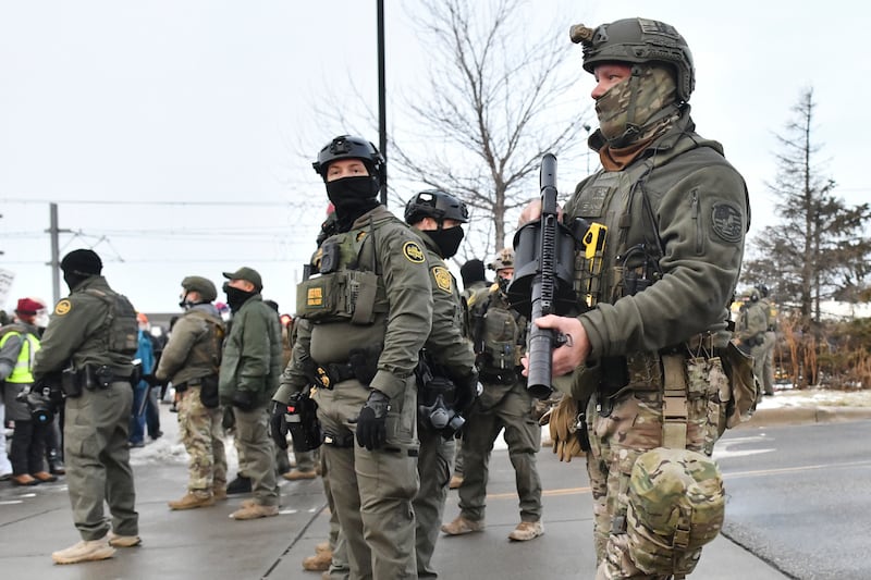 Federal agents stand guard as protestors gather after a federal agent shot and killed 37-year-old Renee Nicole Good. Photograph: Getty 