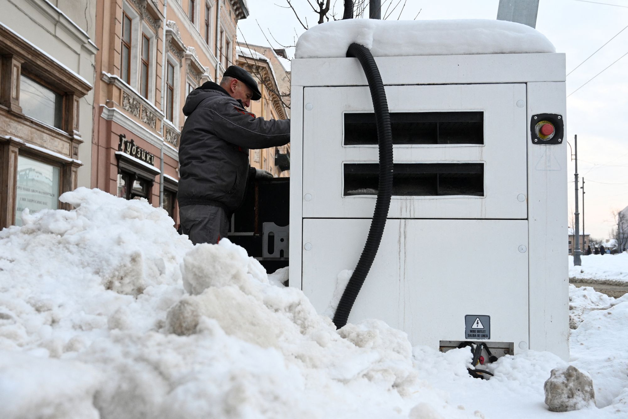 An employee refuels a power generator outside a shop during a scheduled power outage in the centre of Lviv, following Russian missile and drone attacks on Ukrainian energy infrastructure