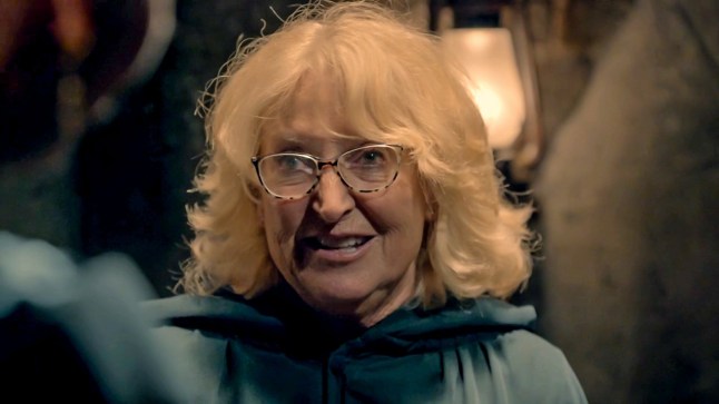 Fiona wears glasses and her cloak as she stands in the turret in The Traitors.