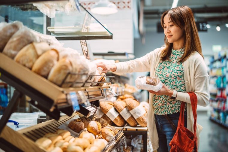 A woman chooses bread at a bakery
