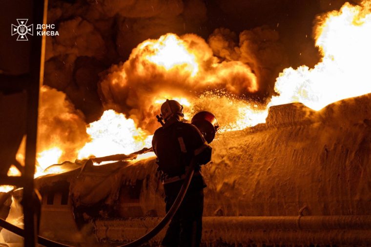 In this handout photograph taken and released by the Ukrainian Emergency Service on January 24, 2026, a Ukrainian rescuer works to extinguish a burning petrol truck following an air attack in Kyiv, amid the Russian invasion of Ukraine. Russian strikes killed one person and injured 23 others in Ukraine's capital and the northeastern city of Kharkiv overnight, authorities said early on January 24, 2026. (Photo by Handout / UKRAINIAN EMERGENCY SERVICE / AFP via Getty Images) / RESTRICTED TO EDITORIAL USE - MANDATORY CREDIT "AFP PHOTO / UKRAINIAN EMERGENCY SERVICE" - NO MARKETING NO ADVERTISING CAMPAIGNS - DISTRIBUTED AS A SERVICE TO CLIENTS
