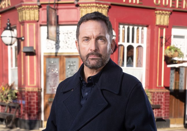 Jake Moon poses in front of the Vic in EastEnders
