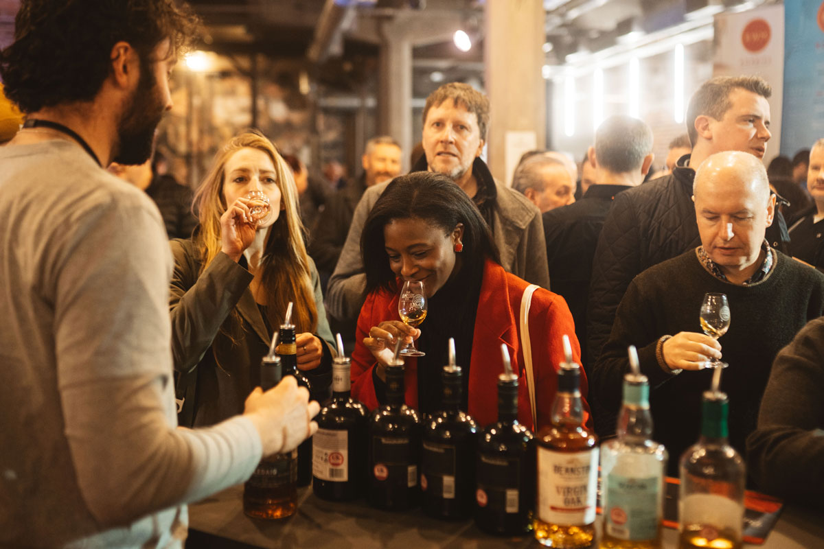 Two ladies sample whisky at a trade stand