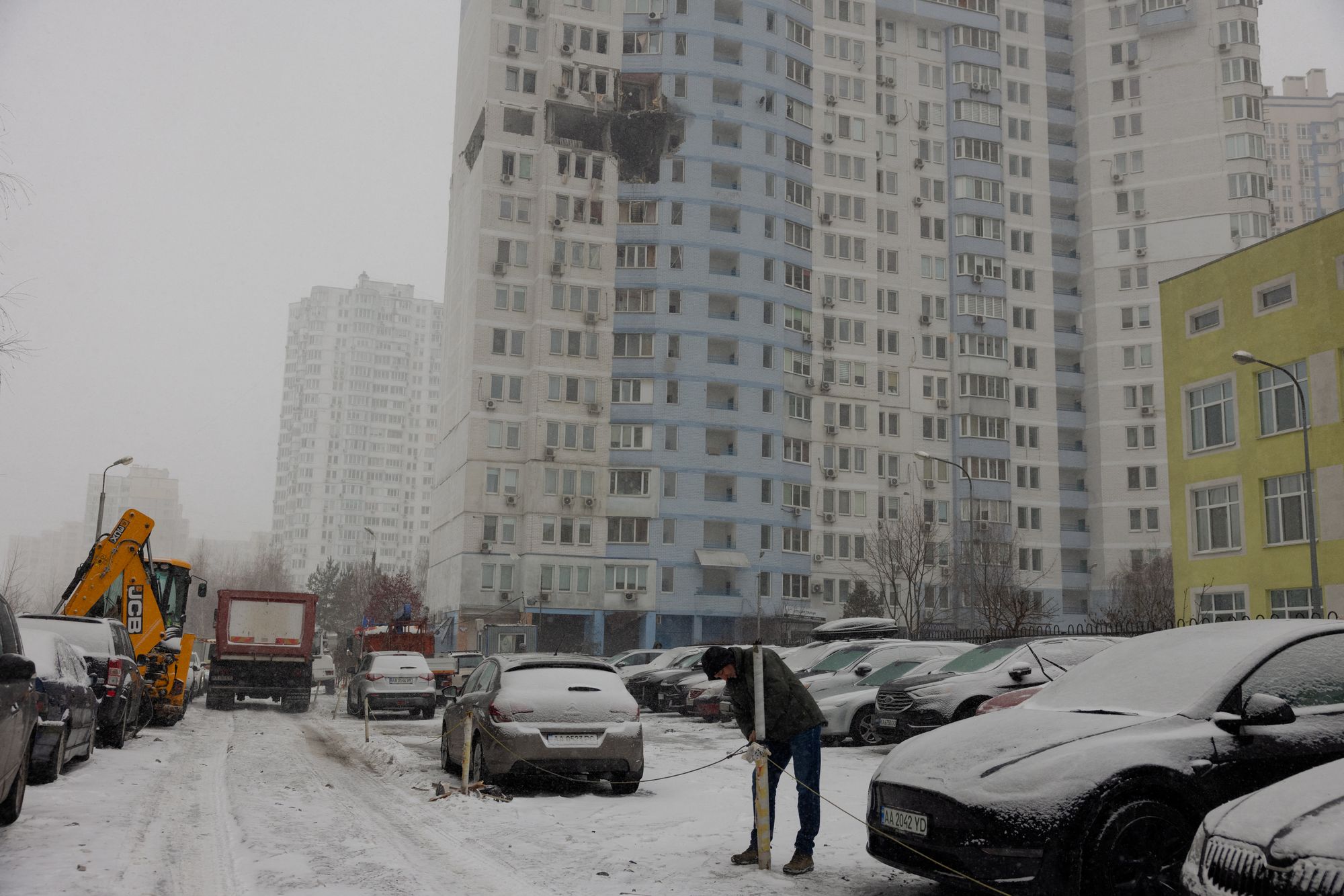 A man stands near a damaged residential building following a Russian attack in Kyiv