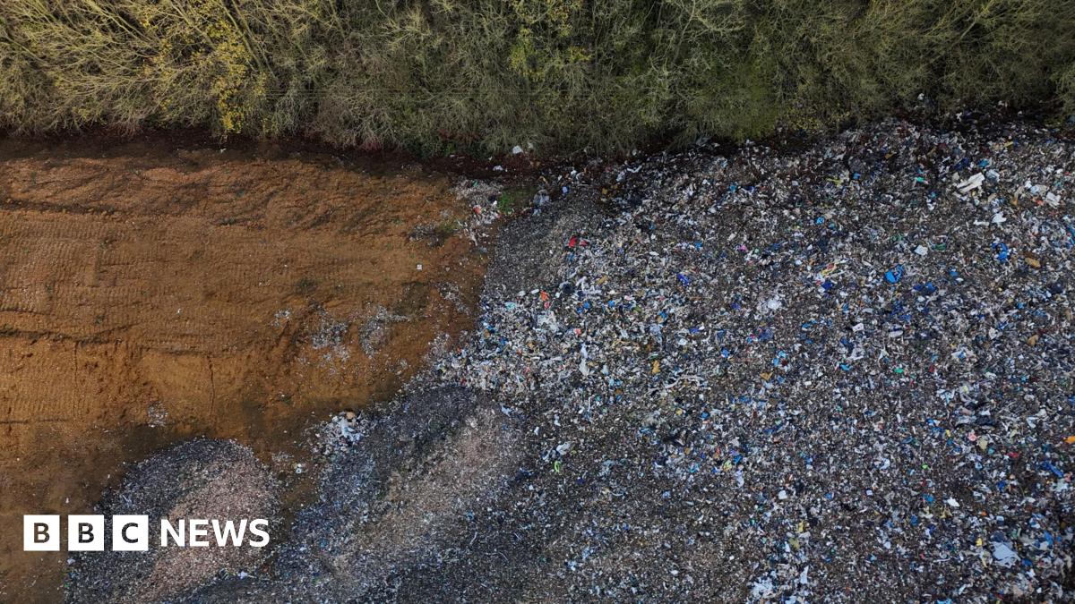 Arborists in orange and yellow high vis uniforms are seen clearing trees and branches form the waste dump site near Kidlington.