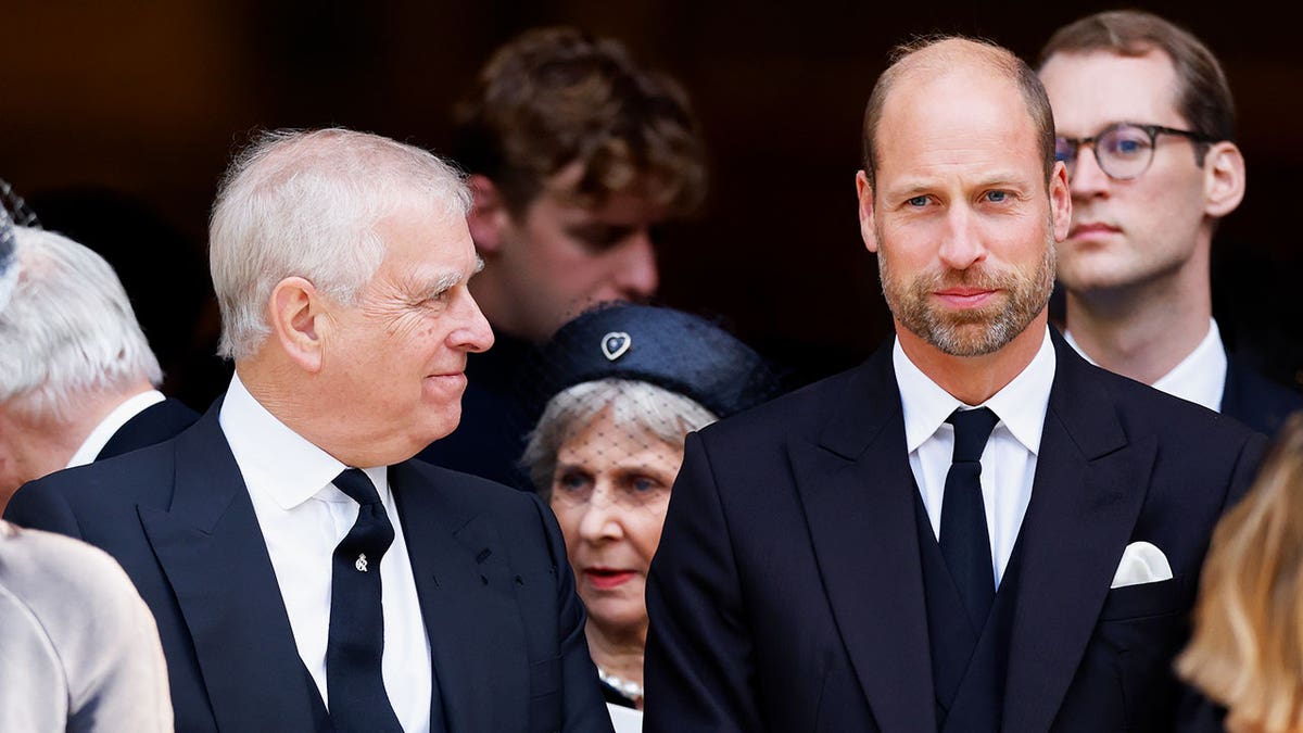 Andrew Mountbatten-Windsor smiling at Prince William who looks annoyed.