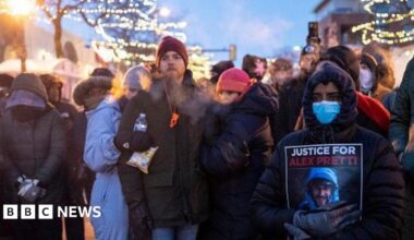 People mourn at a memorial in the area where 37-year-old Alex Pretti was shot dead by federal immigration agents earlier in the day in Minneapolis, Minnesota, on January 24, 2026.