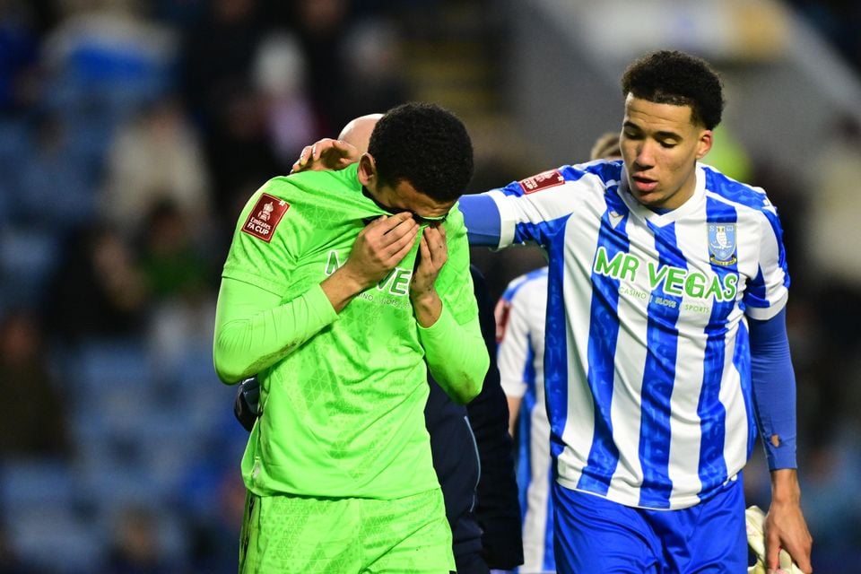 Sheffield Wednesday's Northern Ireland goalkeeper Pierce Charles (left) is comforted by team-mate Gabriel Otegbayo while walking off the pitch on Saturday