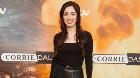 PA Media Julia Goulding smiling and standing in front of Corriedale branded backdrop 