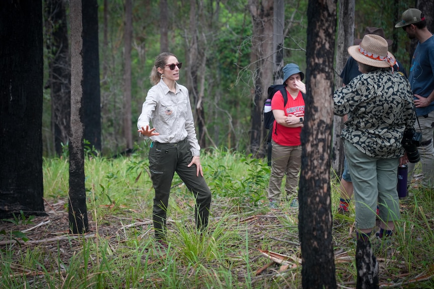 A group of people stand around in the bush