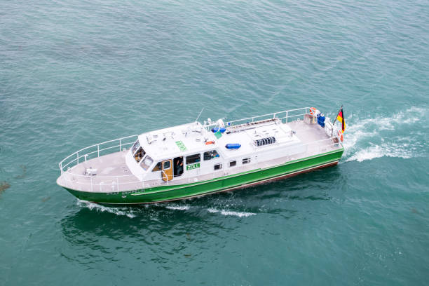 German police patrol boat travels across open water, with the German flag visible at the stern.