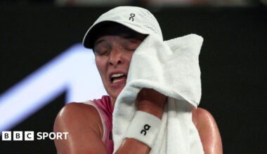 Iga Swiatek rubs her face with a towel at the 2025 Australian Open