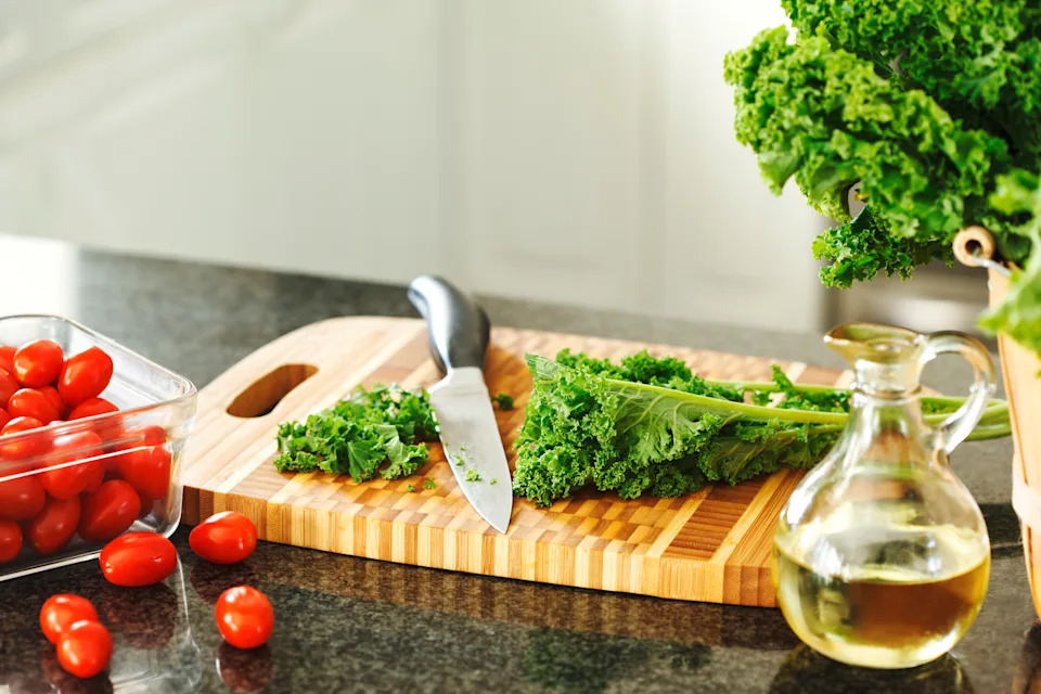 Kale and tomatoes on the kitchen table. Preparing healthy food.