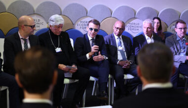 A group of European political leaders in suits and ties sit on cushioned chairs at the World Economic Forum.