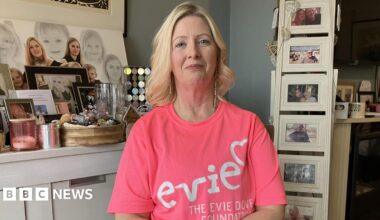 Prime Minister Mark Carney, wearing a black suit jacket, and a white button-up shirt leans his chin on his hands. He has short grey and black hair and is looking away from the camera.