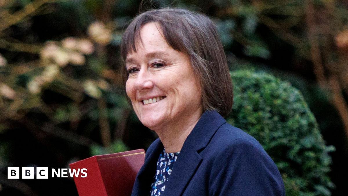 Jo Stevens, a middle-aged woman with short brown hair, smiles as she walks.
