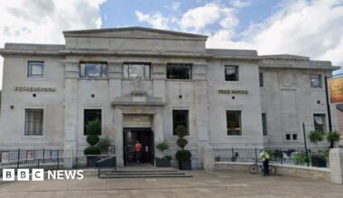 A queue of people line up outside the Golden Beam pub.