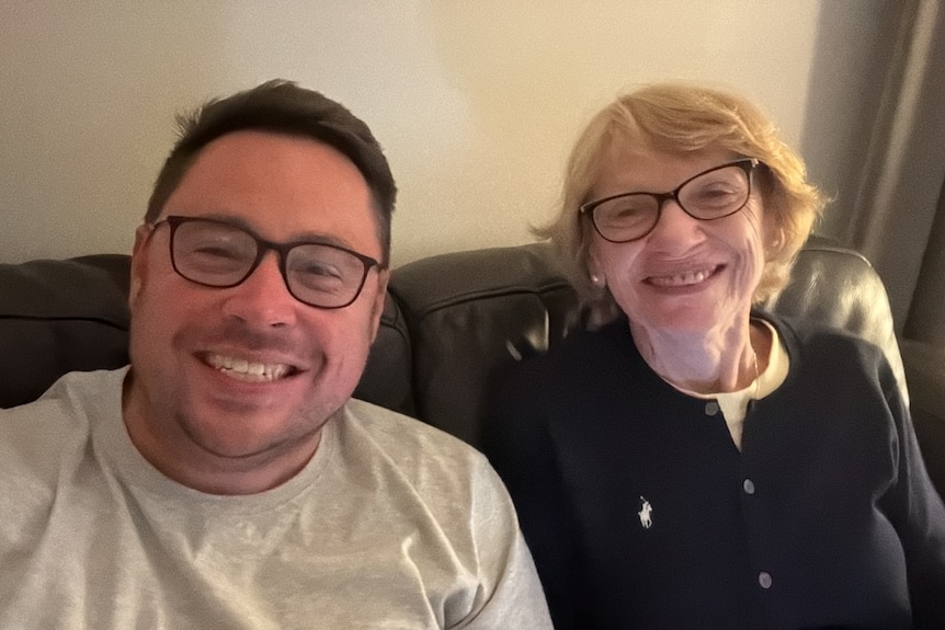 A woman and a man sit next to each other on the couch.