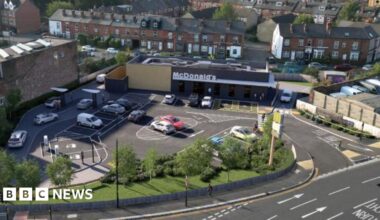 Prime Minister Mark Carney, wearing a black suit jacket, and a white button-up shirt leans his chin on his hands. He has short grey and black hair and is looking away from the camera.