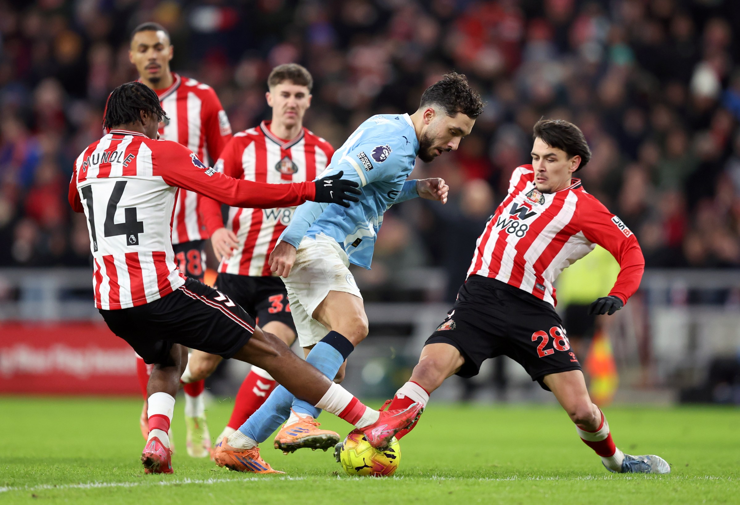 SUNDERLAND, ENGLAND - JANUARY 01: Rayan Cherki of Manchester City is tackled by Romaine Mundle and Enzo Le Fee of Sunderland during the Premier League match between Sunderland and Manchester City at Stadium of Light on January 01, 2026 in Sunderland, England. (Photo by Matt McNulty/Getty Images)
