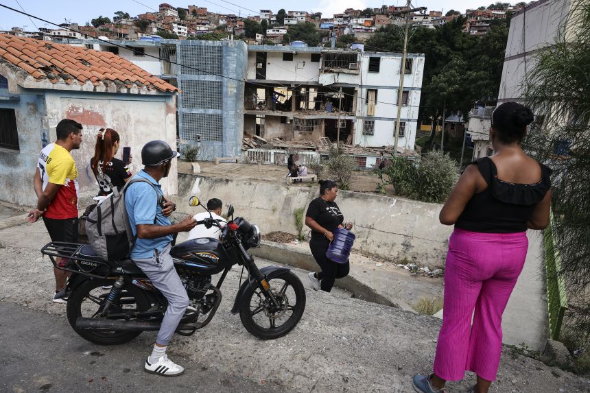 People view an apartment building on January 4, 2026, in La Guaira, Venezuela, that residents say was damaged during US military operations.