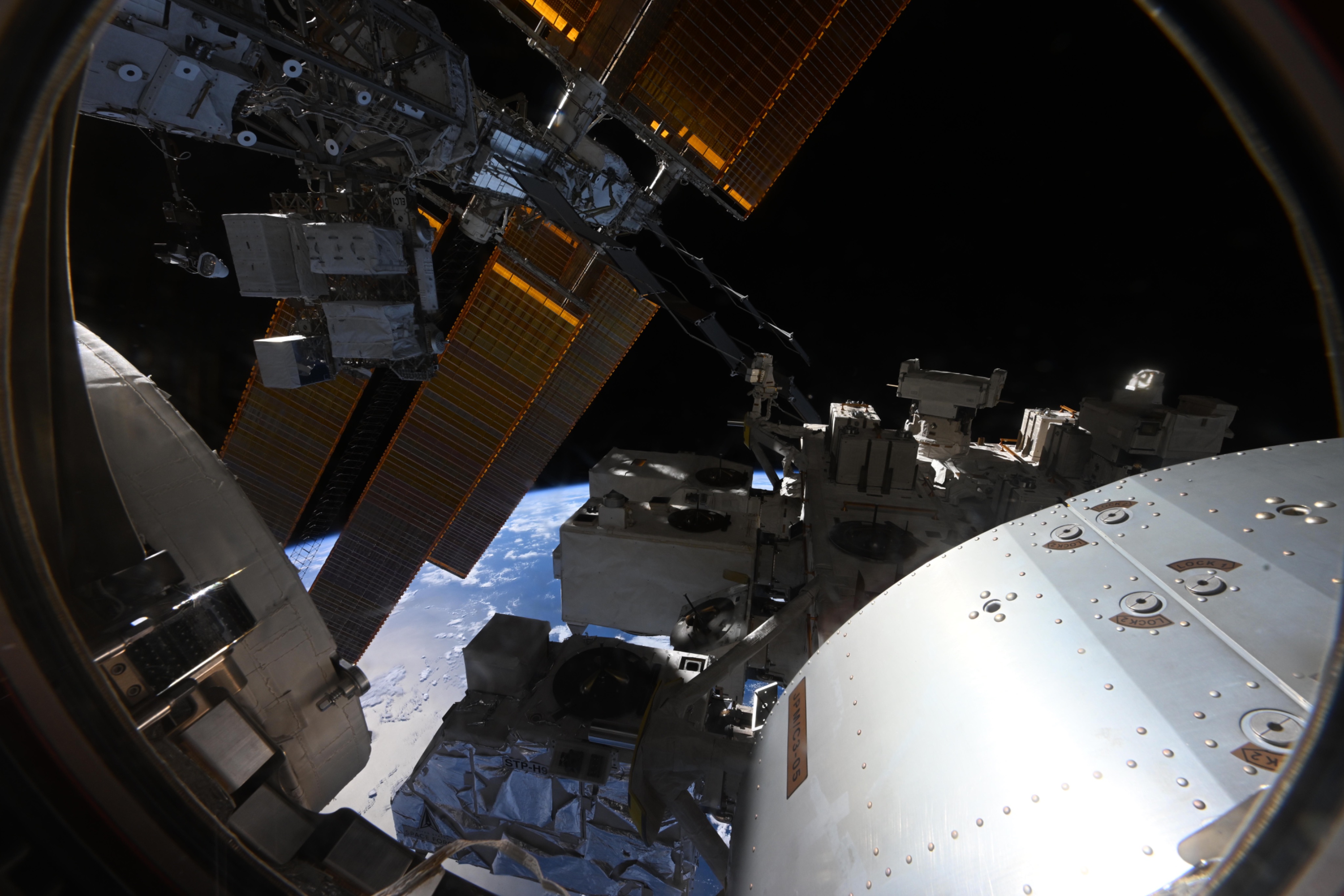 Japan's Kibo space station module and experiment platform above Earth with solar arrays visible