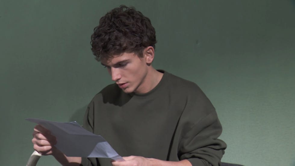 individual reading a document while seated