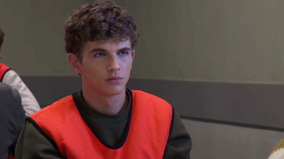 individual wearing an orange vest in a group setting