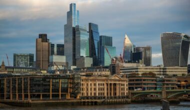 Skyscrapers and modern office buildings rise above older structures along the City of London skyline under a mostly cloudy sky
