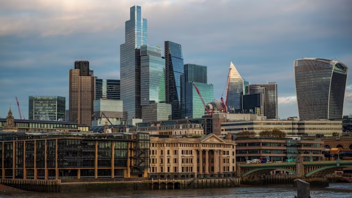 Skyscrapers and modern office buildings rise above older structures along the City of London skyline under a mostly cloudy sky