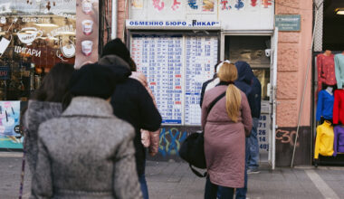 People stand in line at a currency exchange displaying rates in Sofia, Bulgaria, ahead of the euro’s adoption.