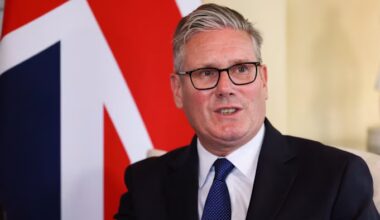 Keir Starmer speaking, seated in front of a large union jack flag