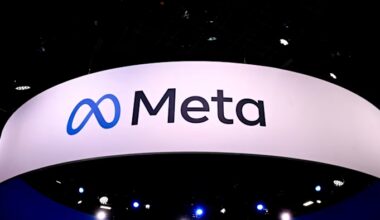 The Meta logo is displayed on a large white sign at a technology fair, with blue stage lights visible below.