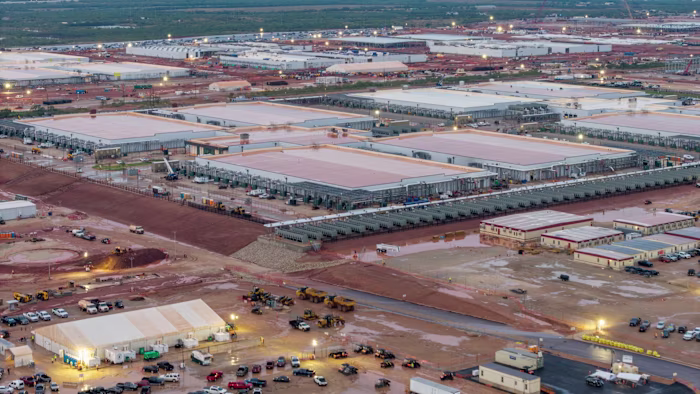Rows of large, low buildings and construction vehicles at the Stargate AI data center site in Abilene, Texas.