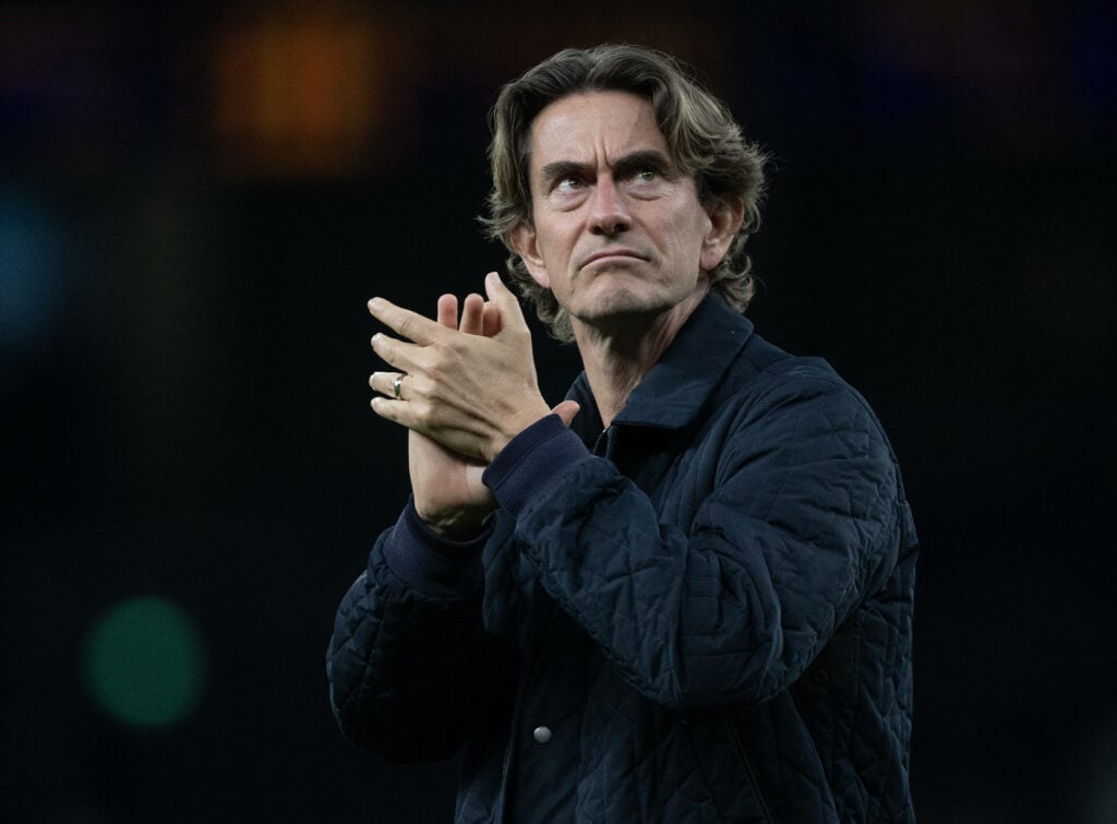 Thomas Frank looking serious whilst clapping for Tottenham