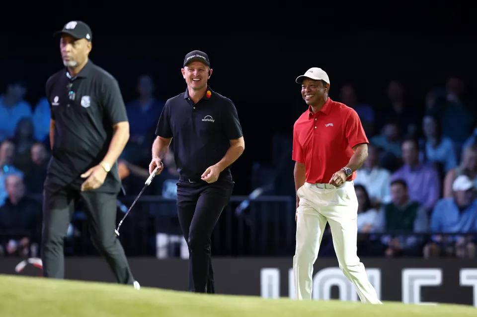 Justin Rose of Los Angeles Golf Club (L) and Tiger Woods of Jupiter Links Golf Club walk across the first green at the SoFi Center on January 20, 2026 in Palm Beach Gardens, Florida.