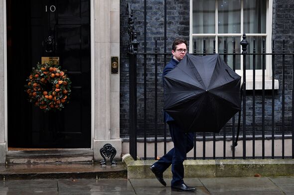 Alex Burghart in Downing Street with an umbrella
