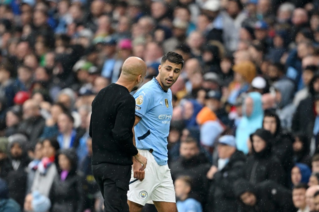 MANCHESTER, ENGLAND - SEPTEMBER 22: Rodri of Manchester City talks to Josep Guardiola, Manager of Manchester City, after leaving the pitch due to an injury during the Premier League match between Manchester City FC and Arsenal FC at Etihad Stadium on September 22, 2024 in Manchester, England. (Photo by Michael Regan/Getty Images)