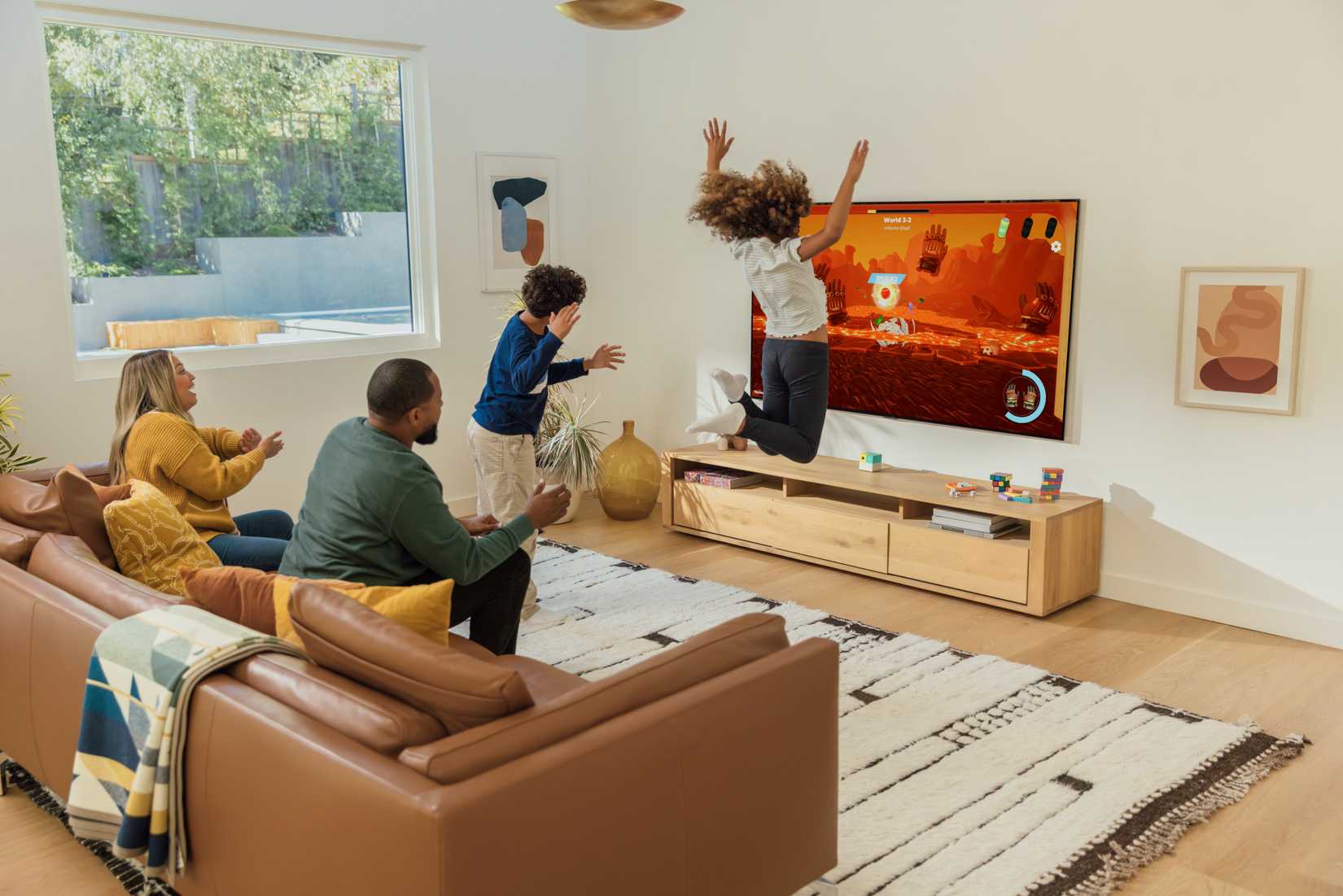 A family playing the Nex Playground, with a daughter jumping in the air