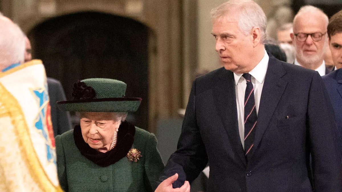 Queen Elizabeth wearing a hunter green coat dress with a matching hat being accompanied by Prince Andrew in a dark suit.