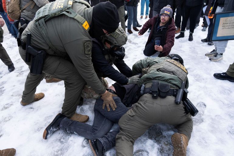 Federal agents tackle a protester to the ground before detaining him outside of the Whipple Federal Building as immigration enforcement action continues, following the fatal shooting of Renee Nicole Good by a U.S. Immigration and Customs Enforcement (ICE) agent, in Minneapolis, Minnesota, U.S., January 8, 2026. REUTERS/Tim Evans