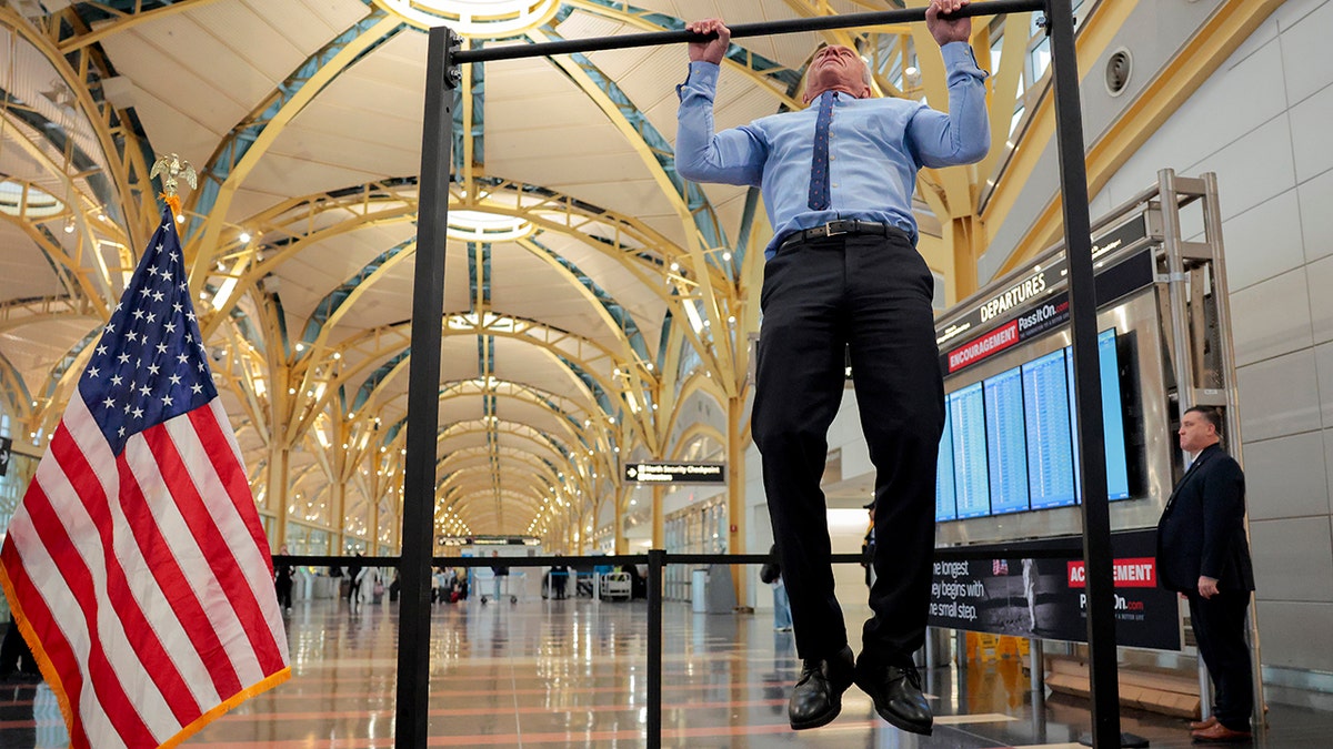 HHS Secretary RFK Jr. does pull-ups after a conference discussing the launch of the "Make Travel Family Friendly Again" campaign at Ronald Reagan Washington National Airport.