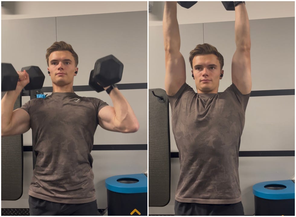 person performing an overhead dumbbell lift in a gym