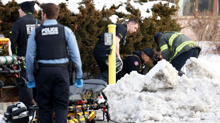 Emergency medical technicians administer aid at the scene of a shooting in Minneapolis. Pic: AP