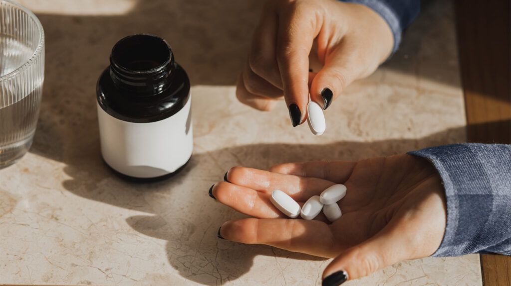 Supplement pills in a person's hand.