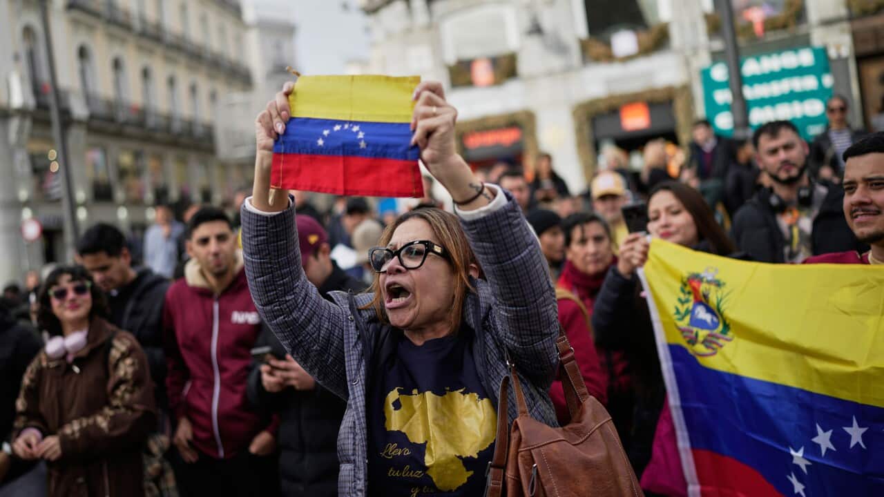 A woman holding the Venezuelan flag up in a march
