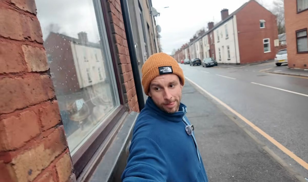 A man stretching his arms across a house