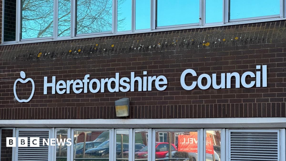 A red brick building with white letting reading "Herefordshire Council".